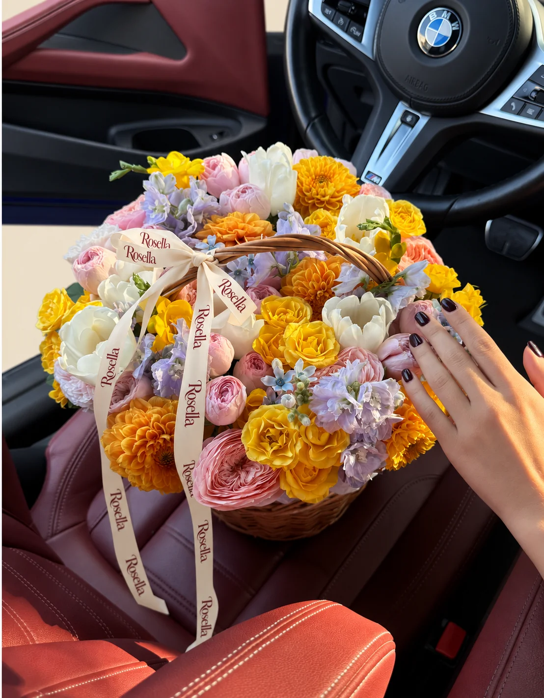 6 dahlias, 19 yellow spray roses, 16 pink spray roses, 4 garden roses, 9 tulips, 2 delphiniums, 3 roses, 3 freesias & 10 tweedia blooms in a basket