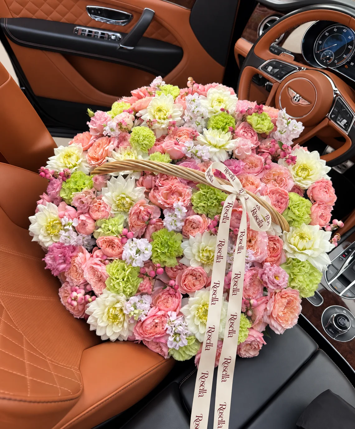 36 peach garden roses, 20 blush garden roses, 15 dahlias, 18 green carnations, 7 stocks & 16 pink carnations in a basket