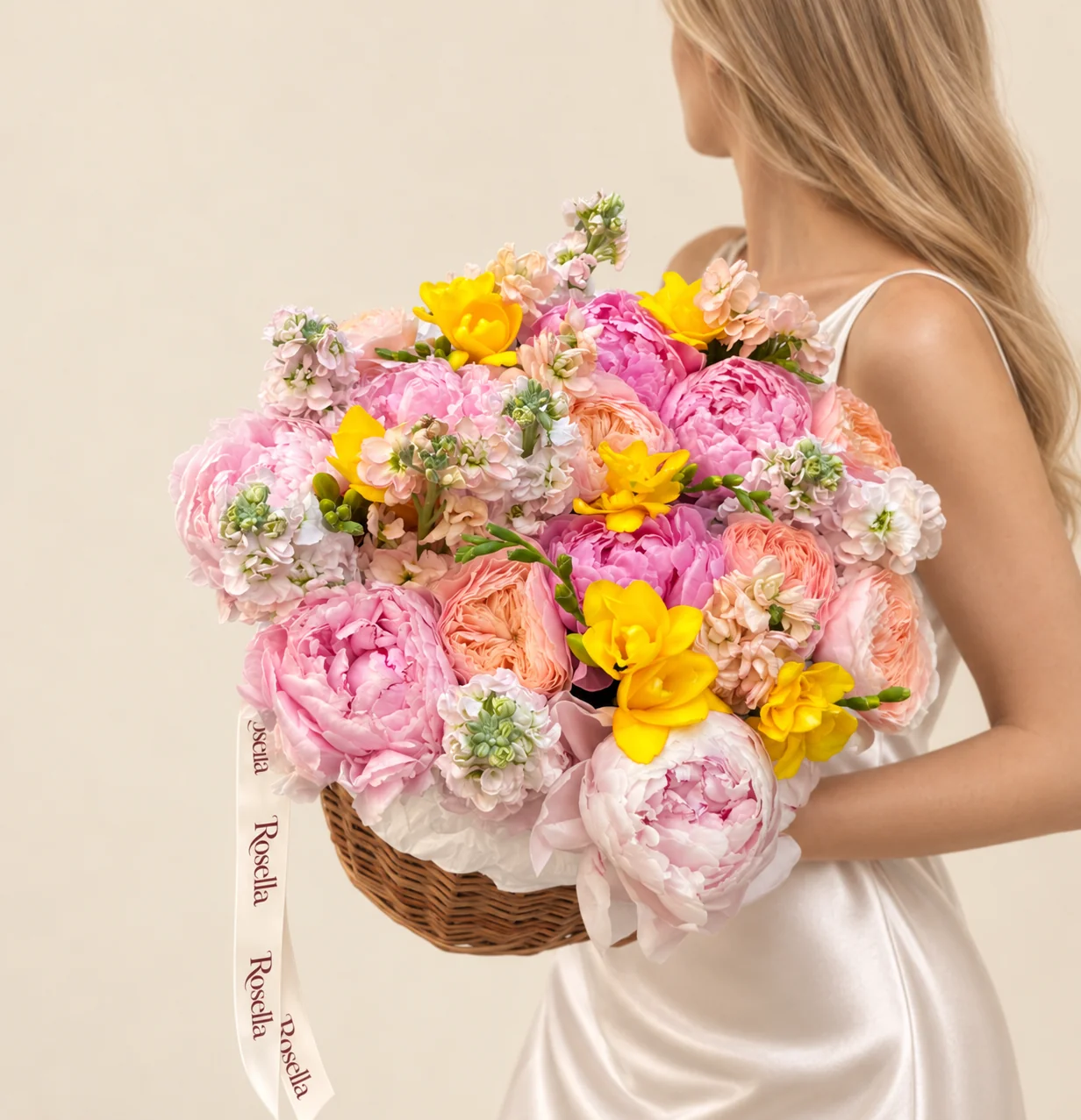 7 garden roses, 5 pink peonies, 5 pink stocks, 4 pink peonies, 3 peach stocks, 4 freesias & 1 cream peony in a basket
