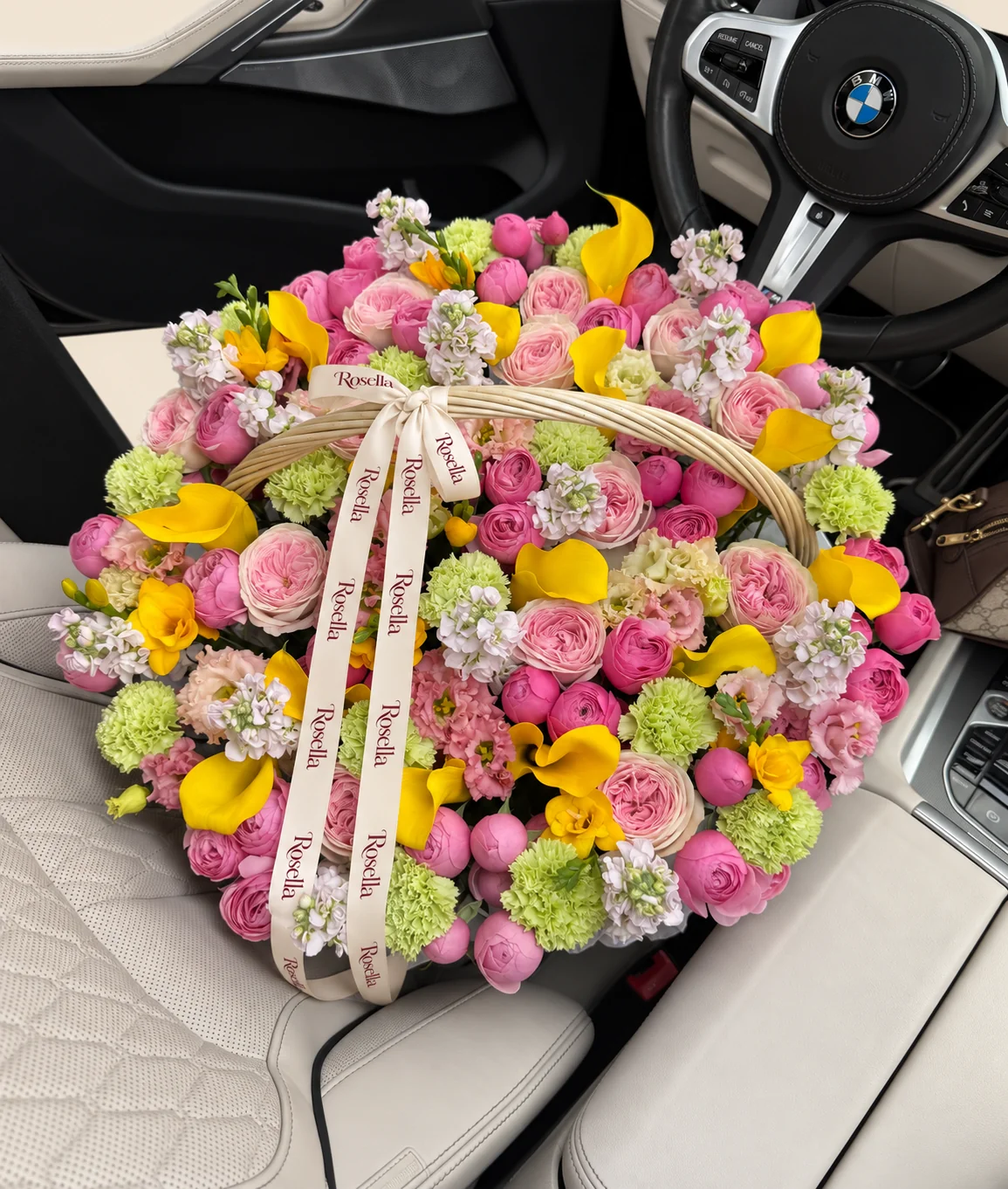 16 garden roses, 58 spray roses, 10 stocks, 19 carnations, 18 callas, 28 peach lisianthus blooms, 6 freesias & 7 cream lisianthus blooms in a basket