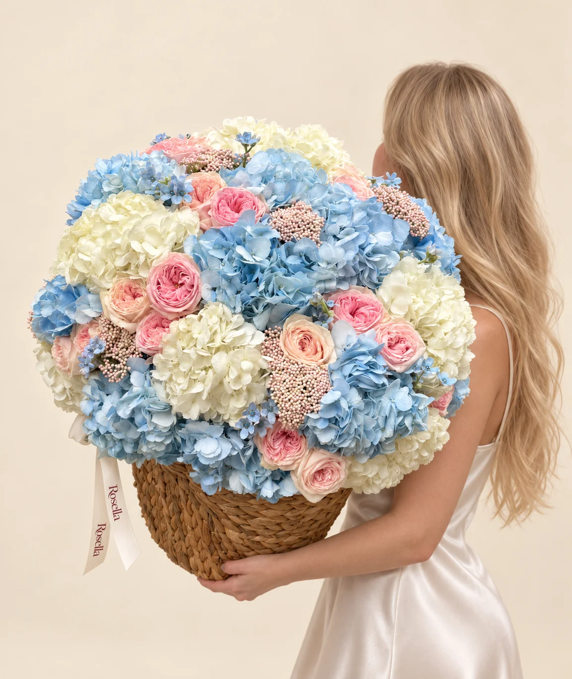 11 blue hydrangeas, 9 ivory hydrangeas, 11 pink garden roses, 7 peach garden roses & 28 tweedia blooms in a basket