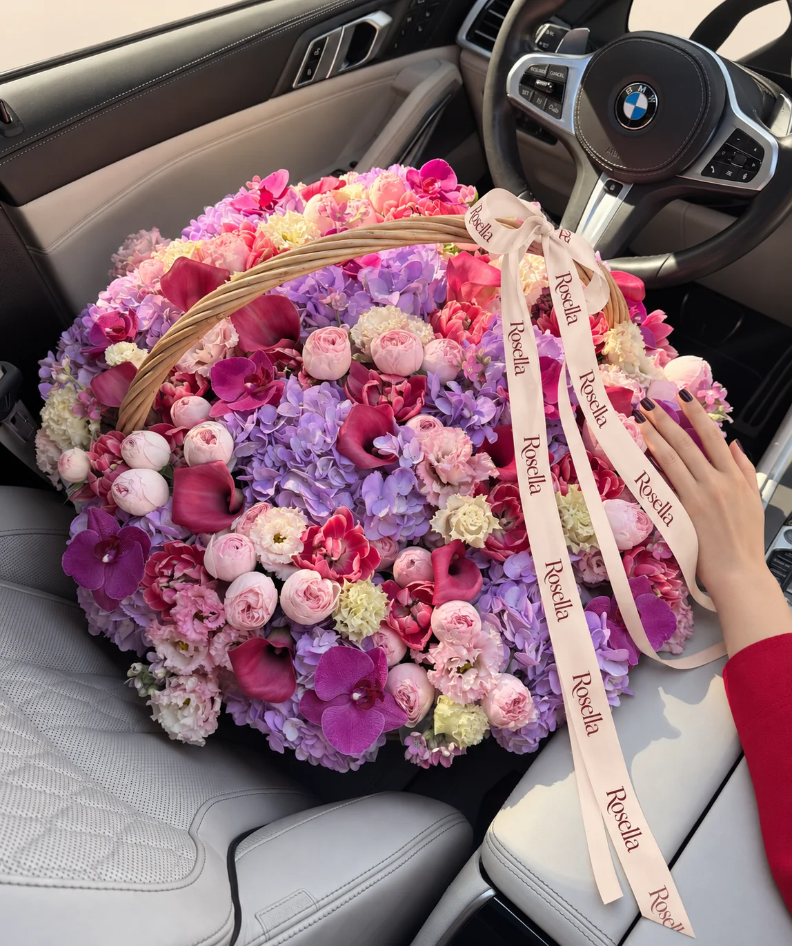 15 hydrangeas, 27 pink garden roses, 27 red orchid blooms, 13 callas, 11 purple orchid blooms, 18 cream lisianthus blooms, 17 pink lisianthus blooms & 3 peach garden roses in a basket