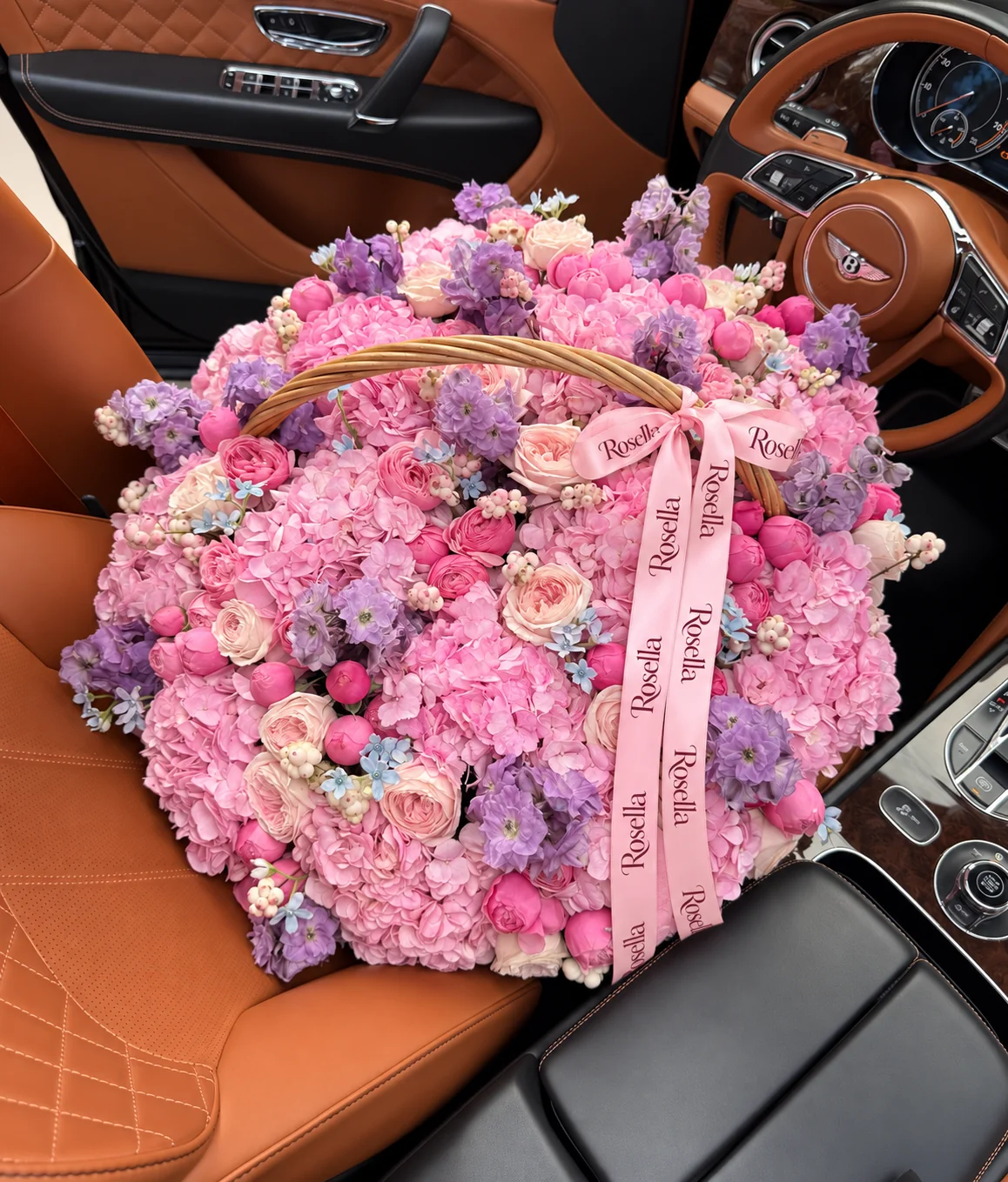 21 hydrangeas, 18 garden roses, 44 spray roses, 5 delphiniums & 52 tweedia blooms in a basket