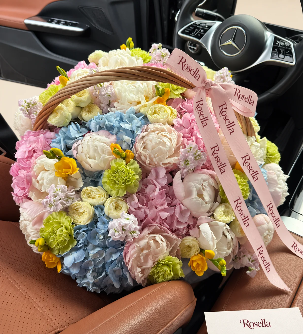 6 blue hydrangeas, 6 pink hydrangeas, 10 blush peonies, 5 ivory peonies, 19 spray roses, 5 stocks, 10 carnations & 4 freesias in a basket