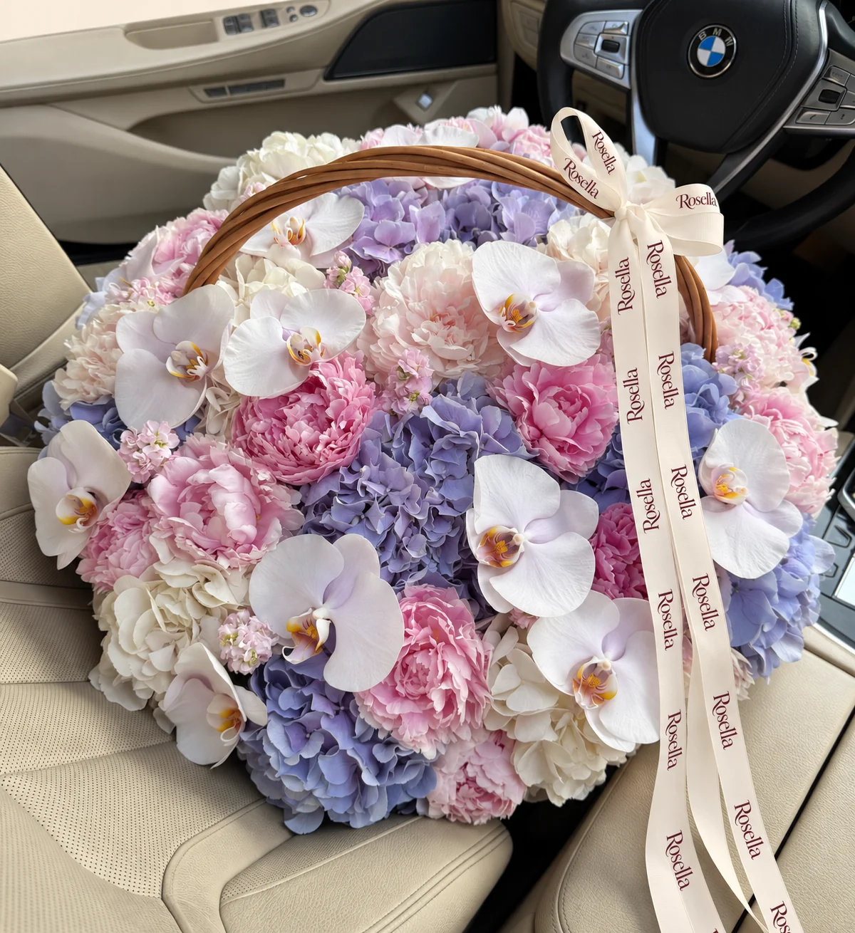 11 lavender hydrangeas, 14 blush peonies, 6 white hydrangeas, 15 orchid blooms, 5 pink peonies, 4 stocks & 3 ivory peonies in a basket