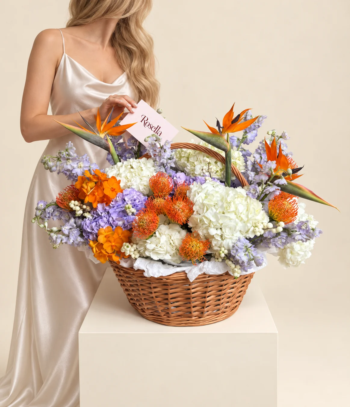 6 white hydrangeas, 8 orange leucospermum (pincushion protea), 6 delphiniums, 17 orchid blooms, 3 lavender hydrangeas & 3 orange and blue strelitzia (bird of paradise) in a basket