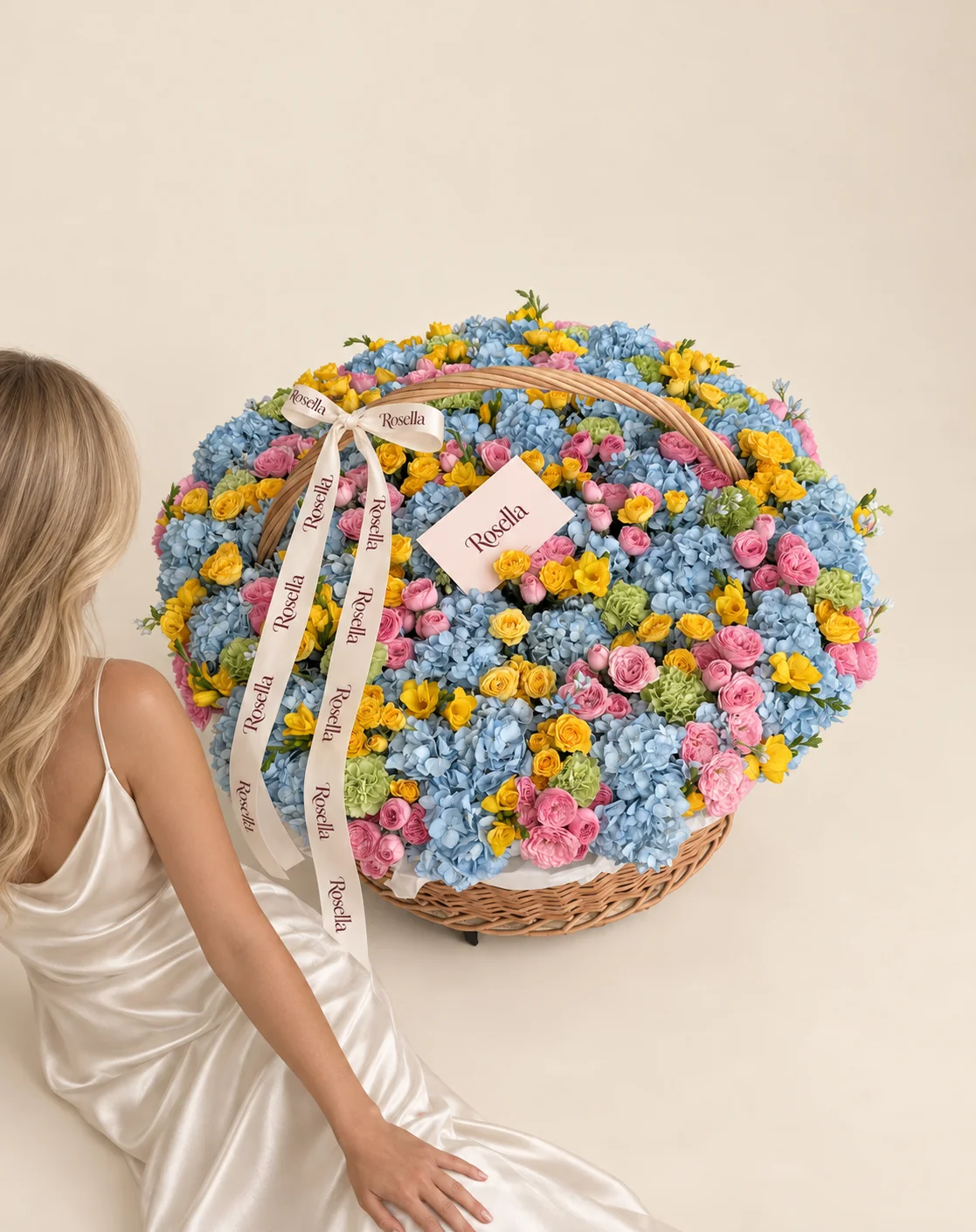 34 hydrangeas, 82 pink spray roses, 52 yellow spray roses, 20 carnations, 16 freesias & 15 tweedia blooms in a basket