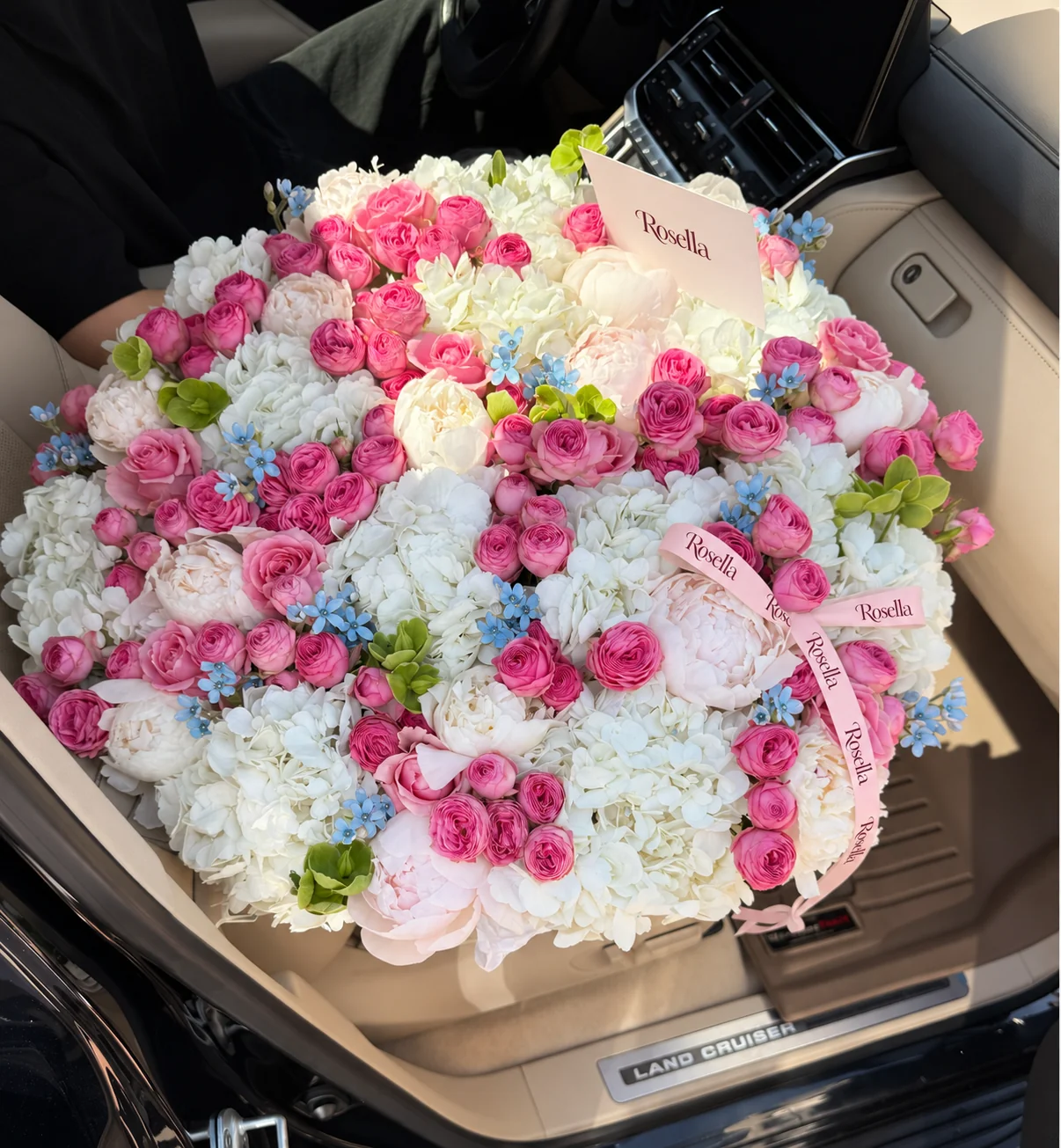 15 hydrangeas, 98 spray roses, 12 white peonies, 78 tweedia blooms, 10 roses, 5 blush peonies & 14 green hellebore in a basket