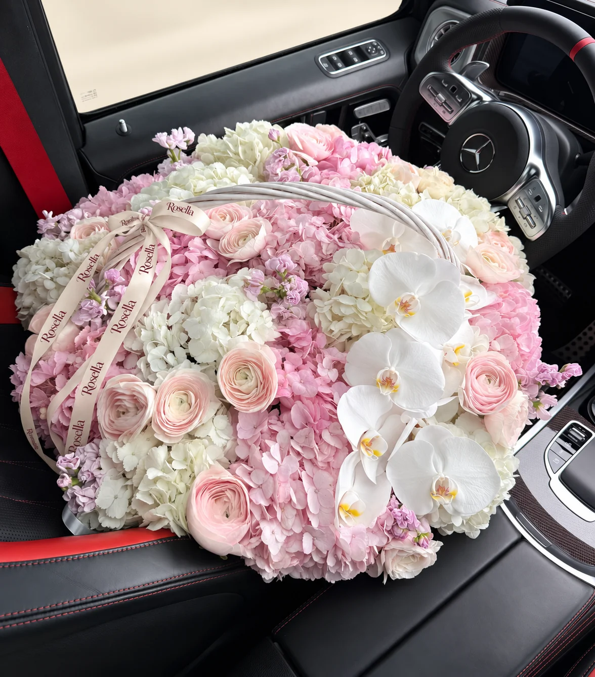 11 white hydrangeas, 9 pink hydrangeas, 14 ranunculus, 11 orchid blooms, 4 stocks, 4 ivory roses & 3 blush roses in a basket