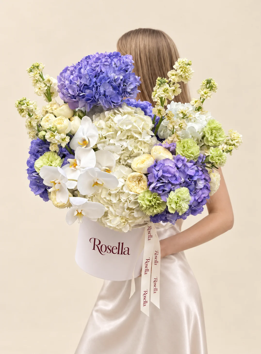 6 blue hydrangeas, 4 white hydrangeas, 9 garden roses, 4 stocks, 8 carnations & 6 orchid blooms in a round box