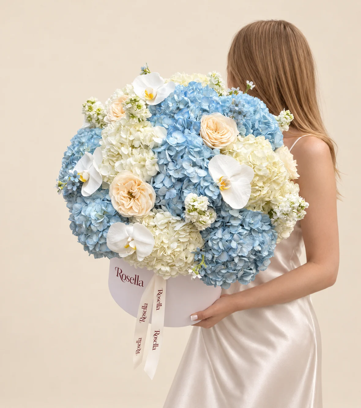 8 blue hydrangeas, 5 ivory hydrangeas, 4 stocks, 4 roses, 4 orchid blooms, 14 tweedia blooms & 1 garden rose in a round box