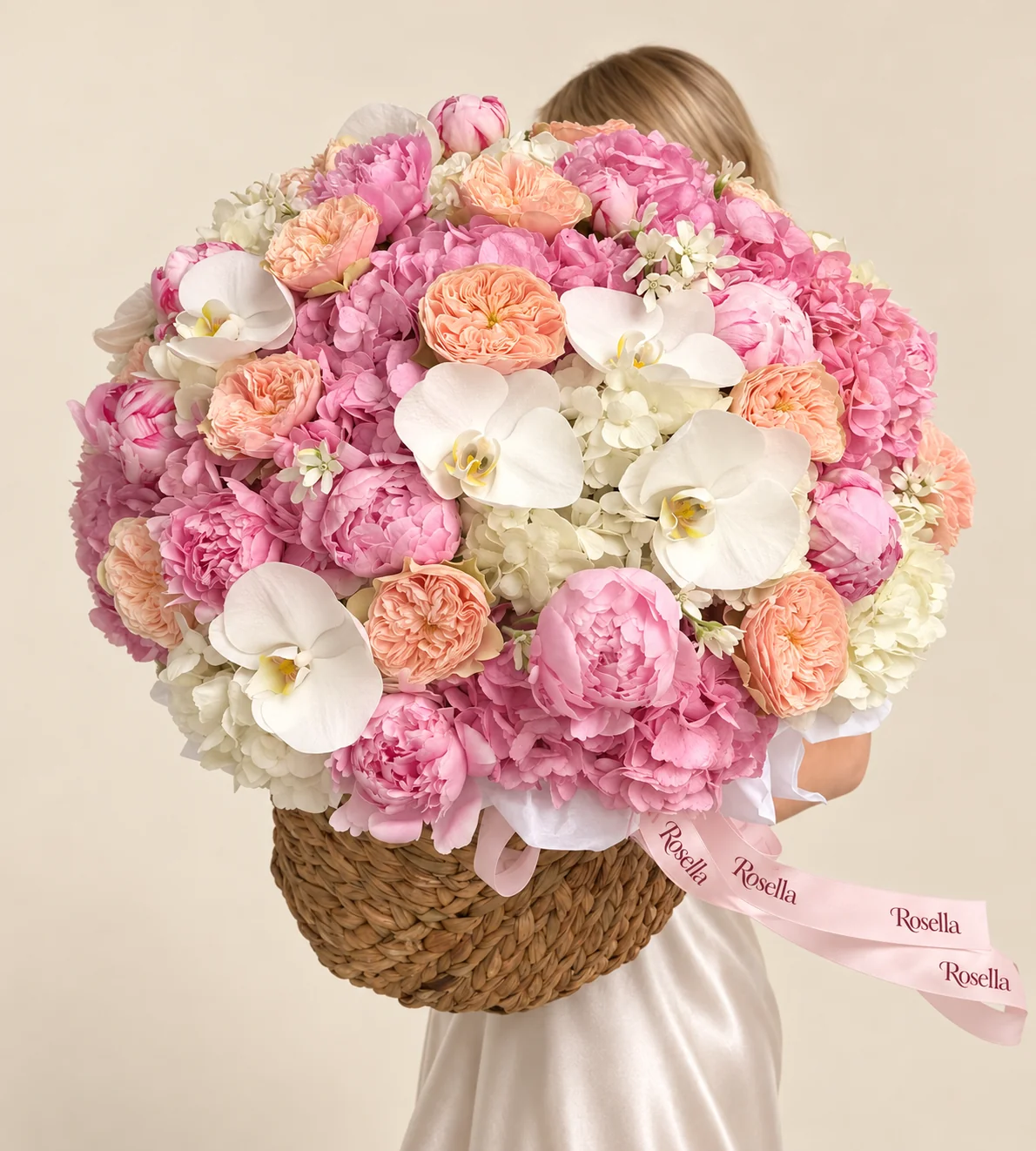 9 pink hydrangeas, 8 white hydrangeas, 14 peonies, 14 peach garden roses, 18 small white star-shaped flowers, 7 orchid blooms & 1 cream garden rose in a basket