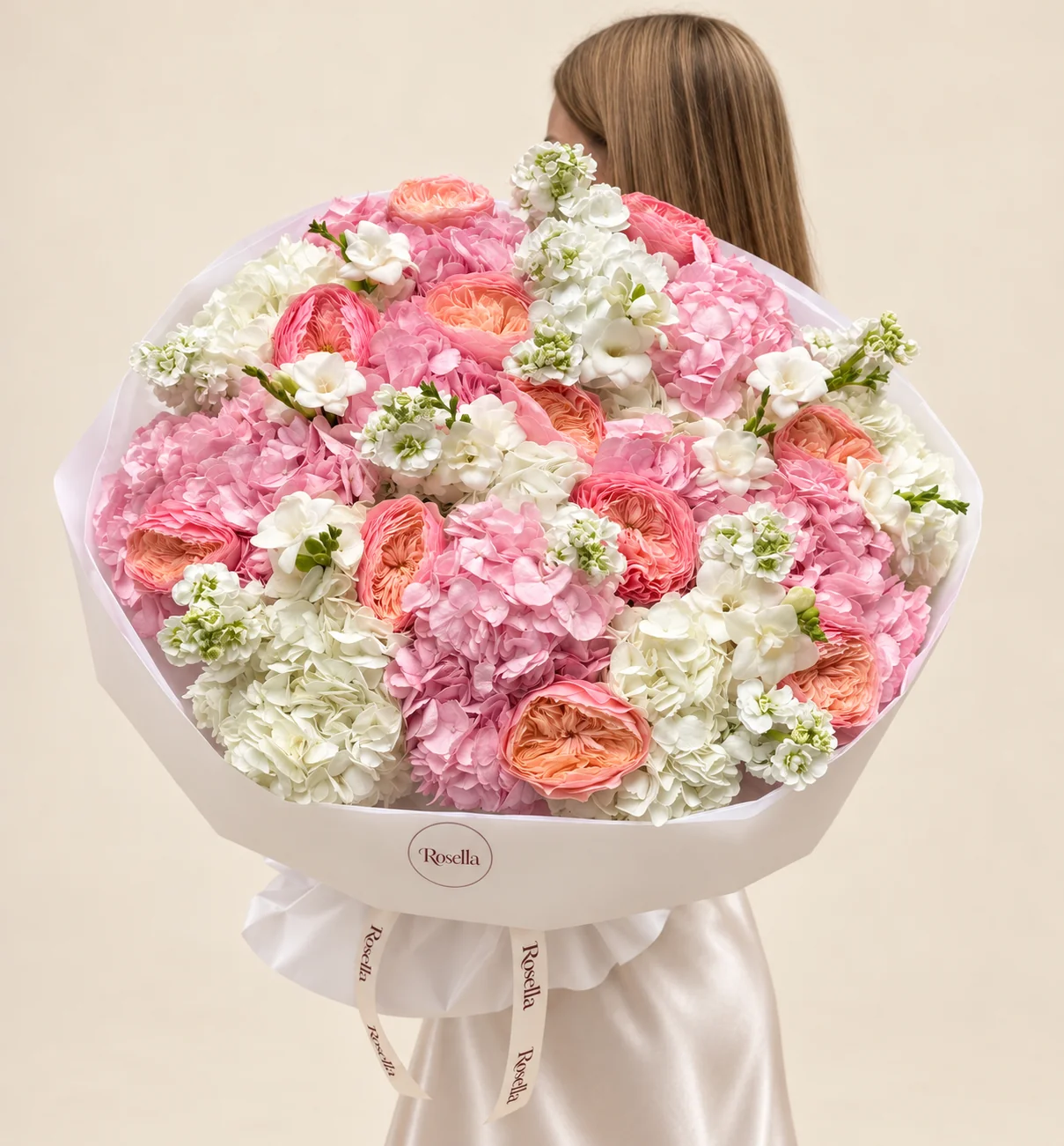 9 pink hydrangeas, 5 white hydrangeas, 10 peach garden roses, 5 stocks, 4 coral garden roses & 8 freesias in a hand-tied bouquet