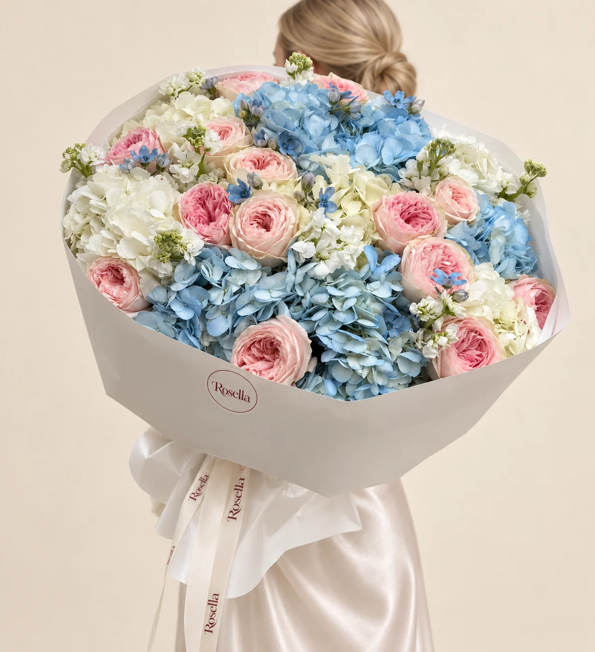17 garden roses, 6 blue hydrangeas, 6 white hydrangeas, 4 stocks & 14 tweedia blooms in a hand-tied bouquet