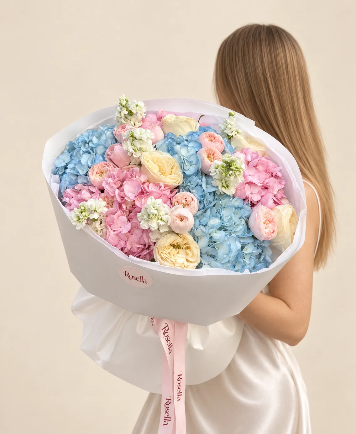 13 blush garden roses, 4 blue hydrangeas, 3 pink hydrangeas, 6 cream garden roses & 5 stocks in a hand-tied bouquet