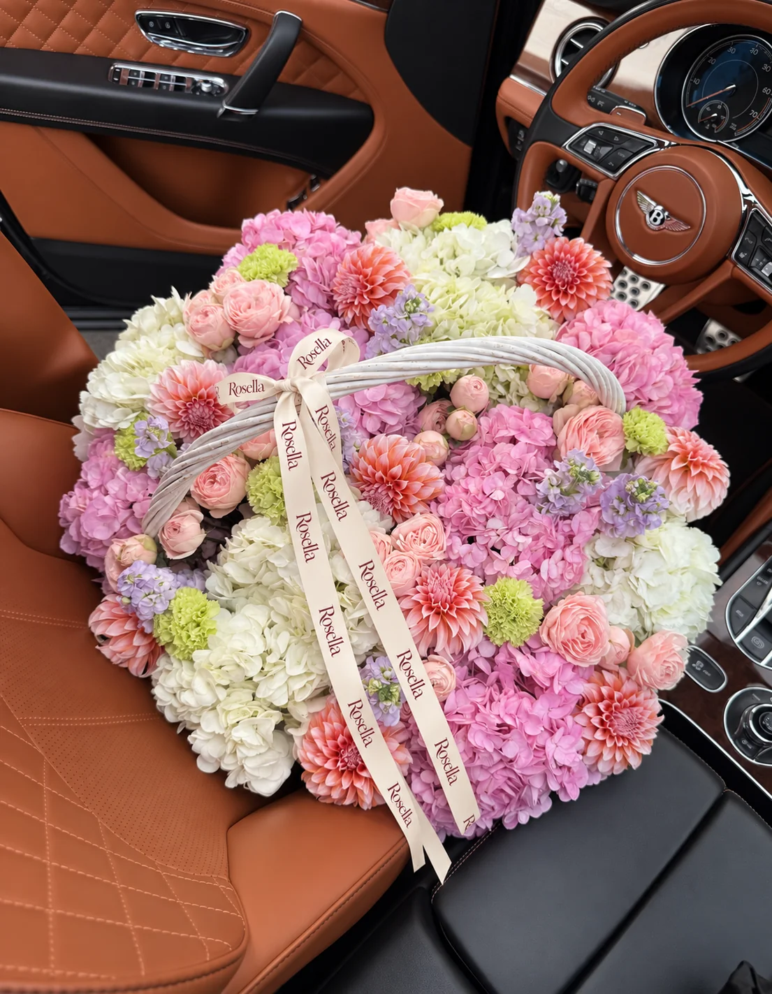 10 pink hydrangeas, 17 garden roses, 7 white hydrangeas, 11 dahlias, 5 stocks, 13 spray roses & 8 carnations in a basket