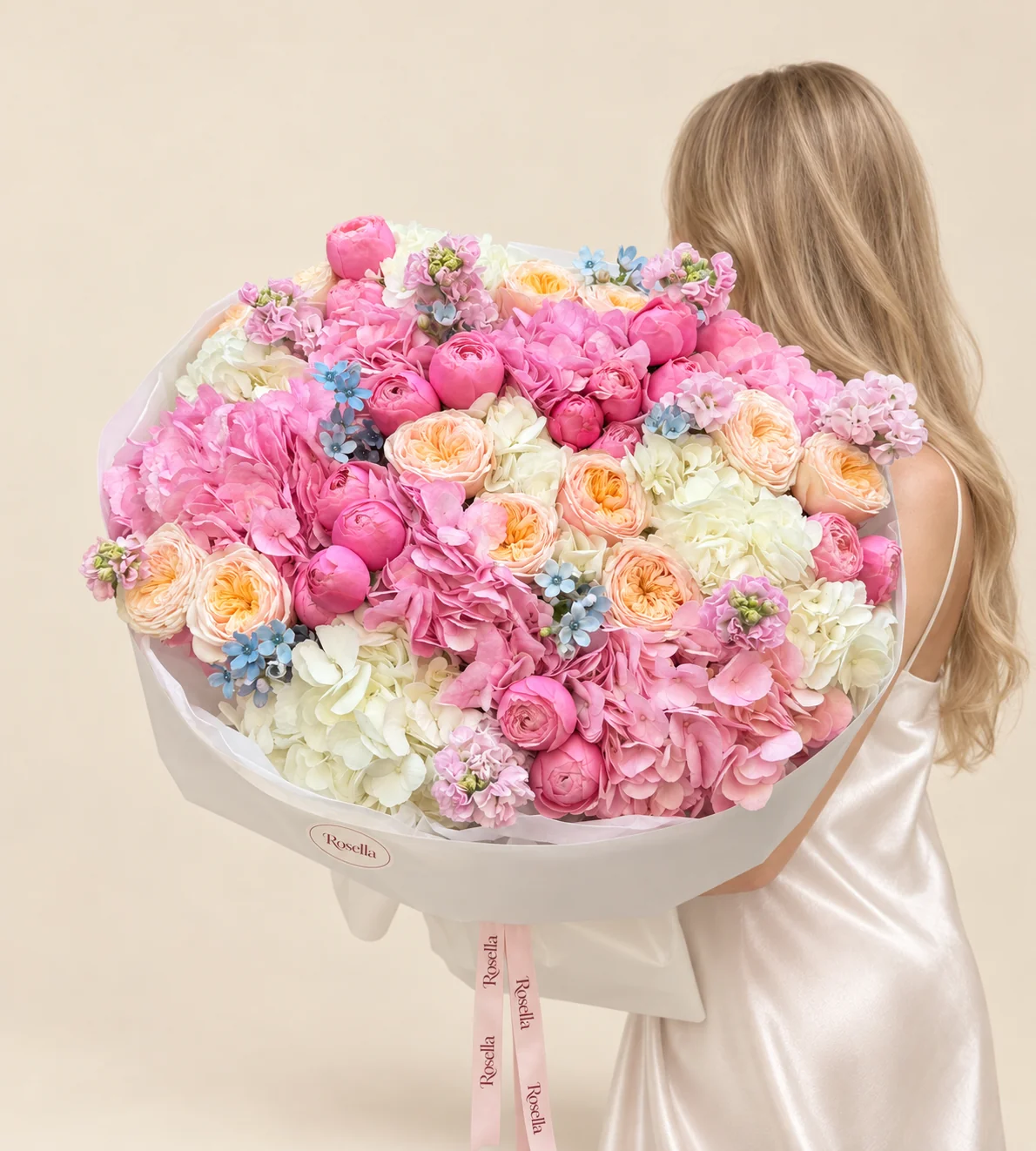10 pink hydrangeas, 23 pink garden roses, 8 white hydrangeas, 15 peach garden roses, 5 stocks & 40 tweedia blooms in a hand-tied bouquet