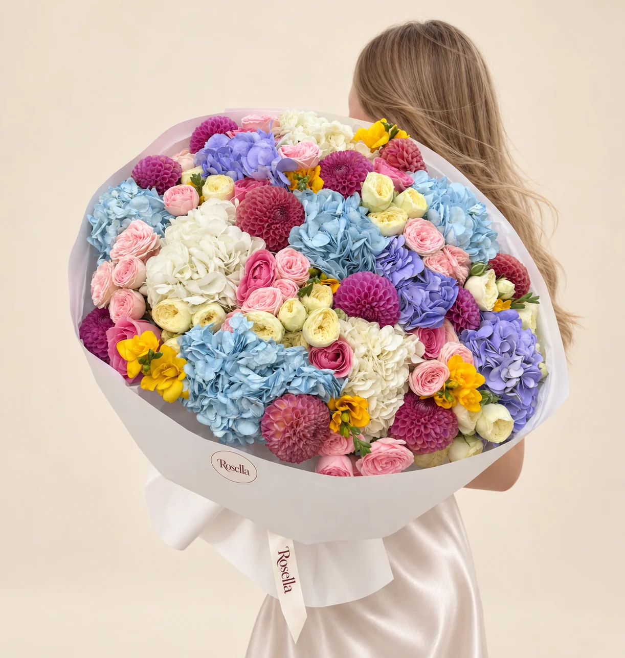6 blue hydrangeas, 4 white hydrangeas, 9 purple dahlias, 14 roses, 3 lavender hydrangeas, 23 cream spray roses, 19 blush spray roses, 4 pink dahlias, 7 freesias & 1 red dahlia in a hand-tied bouquet