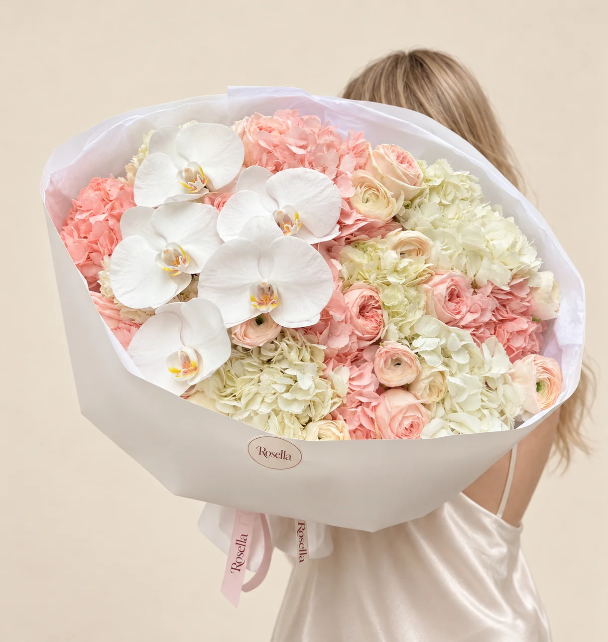 6 peach hydrangeas, 6 ivory hydrangeas, 8 garden roses, 5 cream ranunculus, 5 orchid blooms & 3 peach ranunculus in a hand-tied bouquet