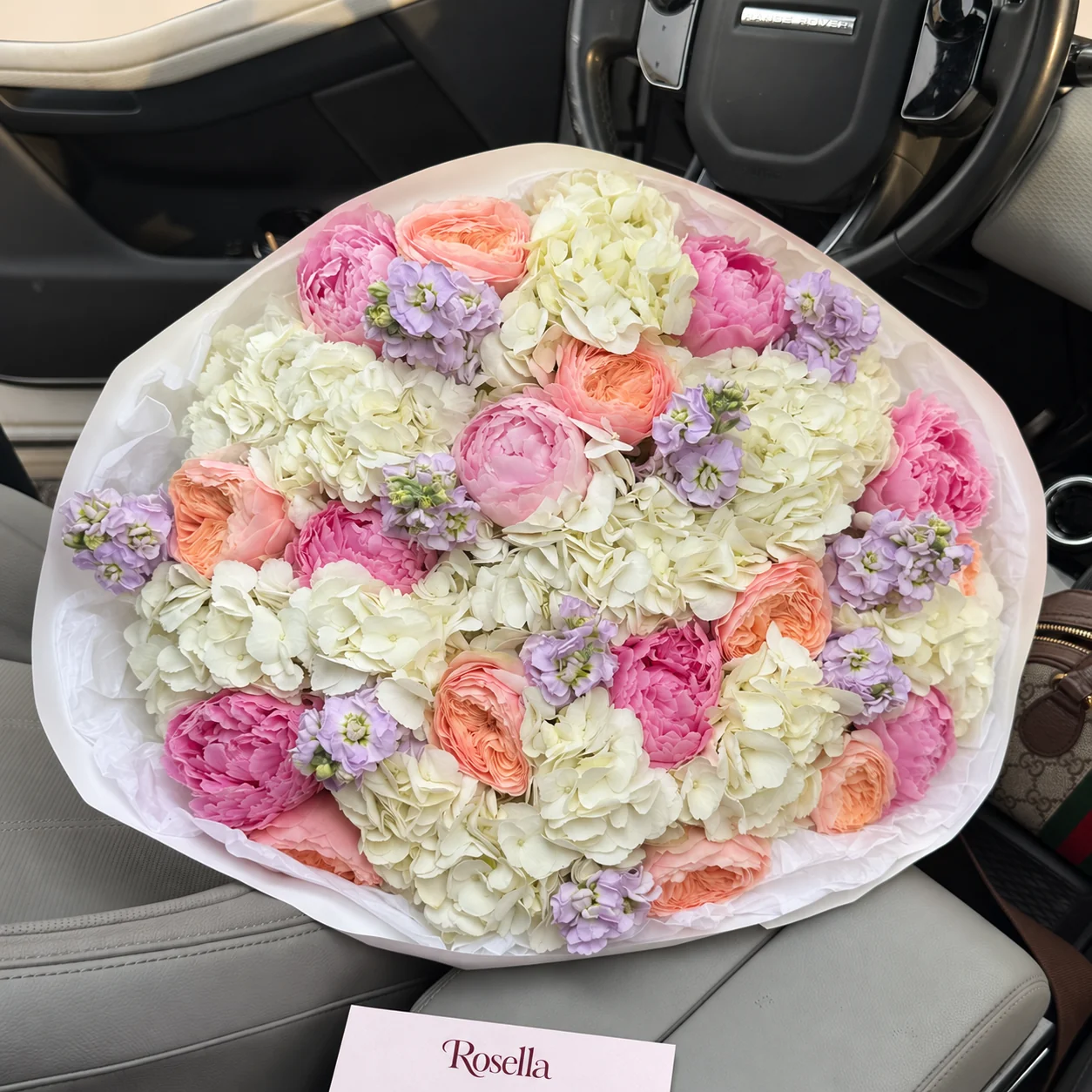 11 hydrangeas, 10 garden roses, 8 pink peonies, 5 stocks & 1 blush peony in a hand-tied bouquet