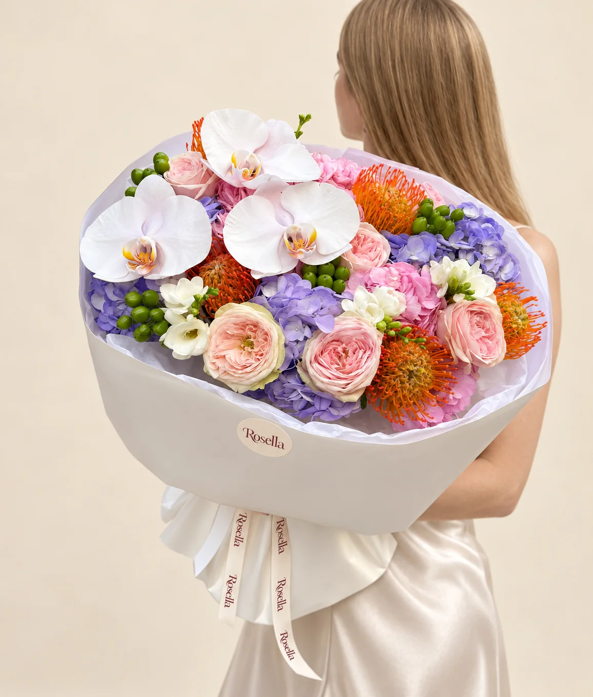 3 lavender hydrangeas, 3 pink hydrangeas, 6 garden roses, 5 orange pincushion protea (leucospermum), 3 orchid blooms & 3 freesias in a hand-tied bouquet