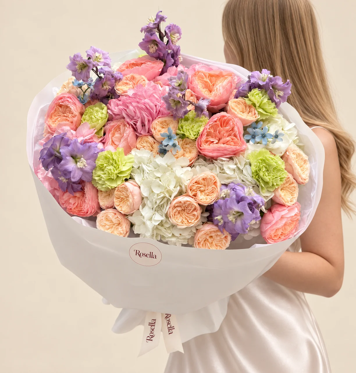 4 white hydrangeas, 9 garden roses, 20 spray roses, 2 pink hydrangeas, 2 delphiniums, 5 carnations & 13 tweedia blooms in a hand-tied bouquet