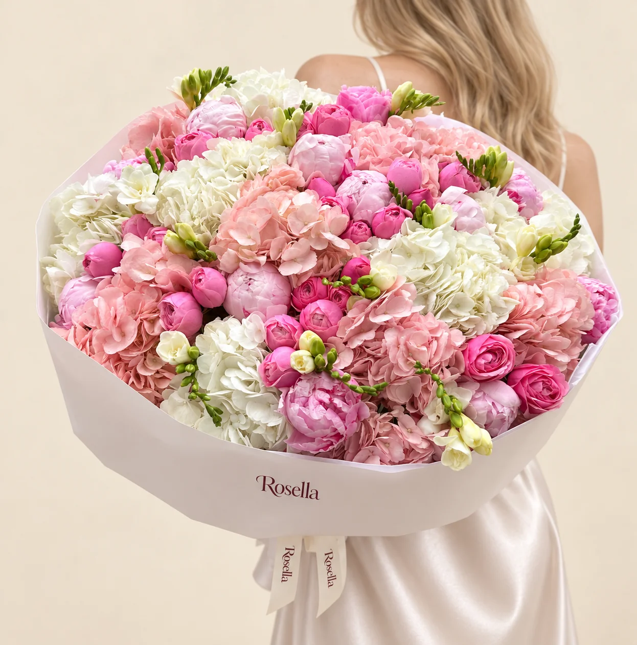 9 blush hydrangeas, 7 white hydrangeas, 13 pink peonies, 28 ranunculus, 6 freesias & 1 pink peony in a hand-tied bouquet