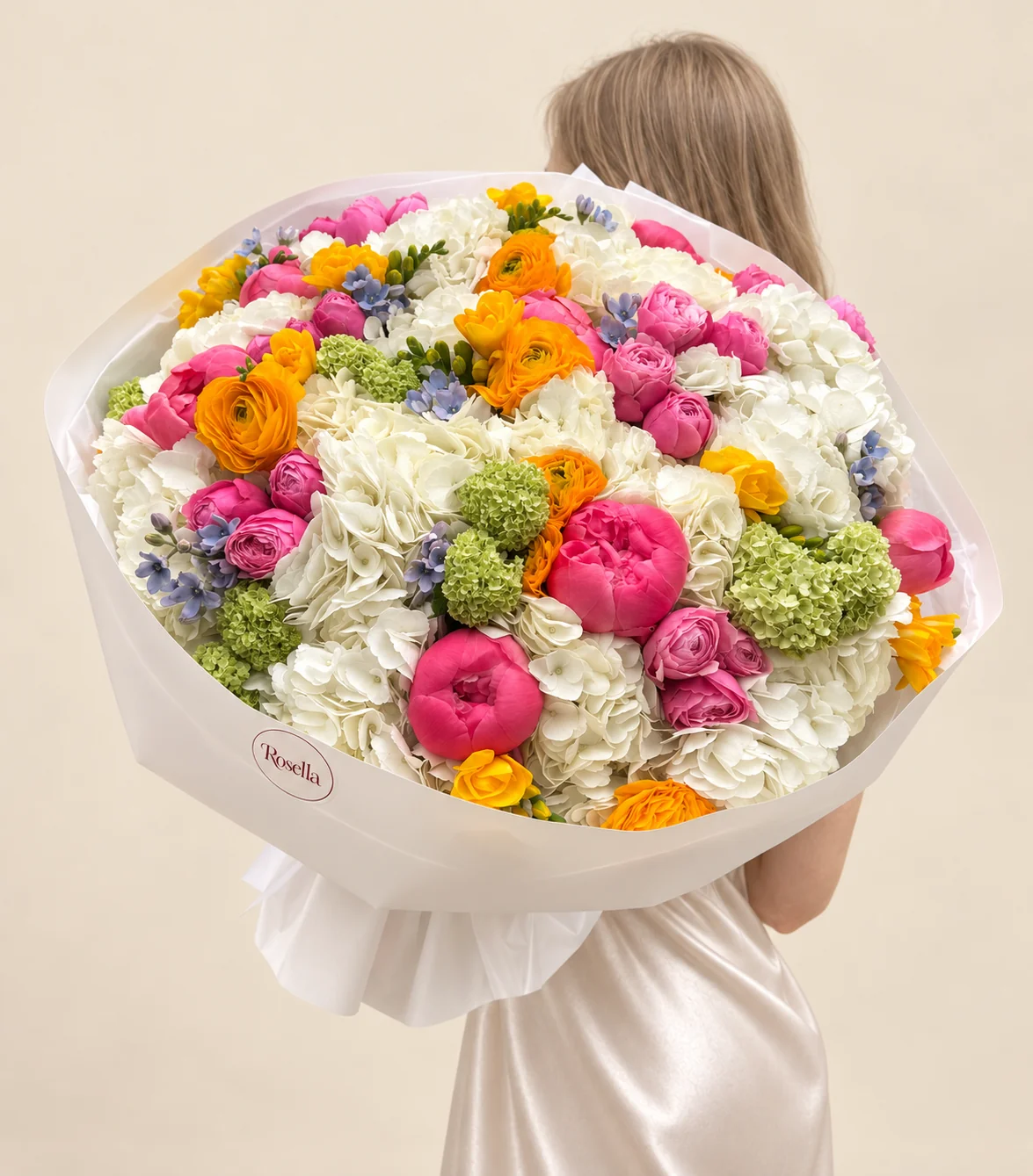 16 hydrangeas, 14 peonies, 15 spray roses, 7 ranunculus, 32 tweedia blooms & 6 freesias in a hand-tied bouquet