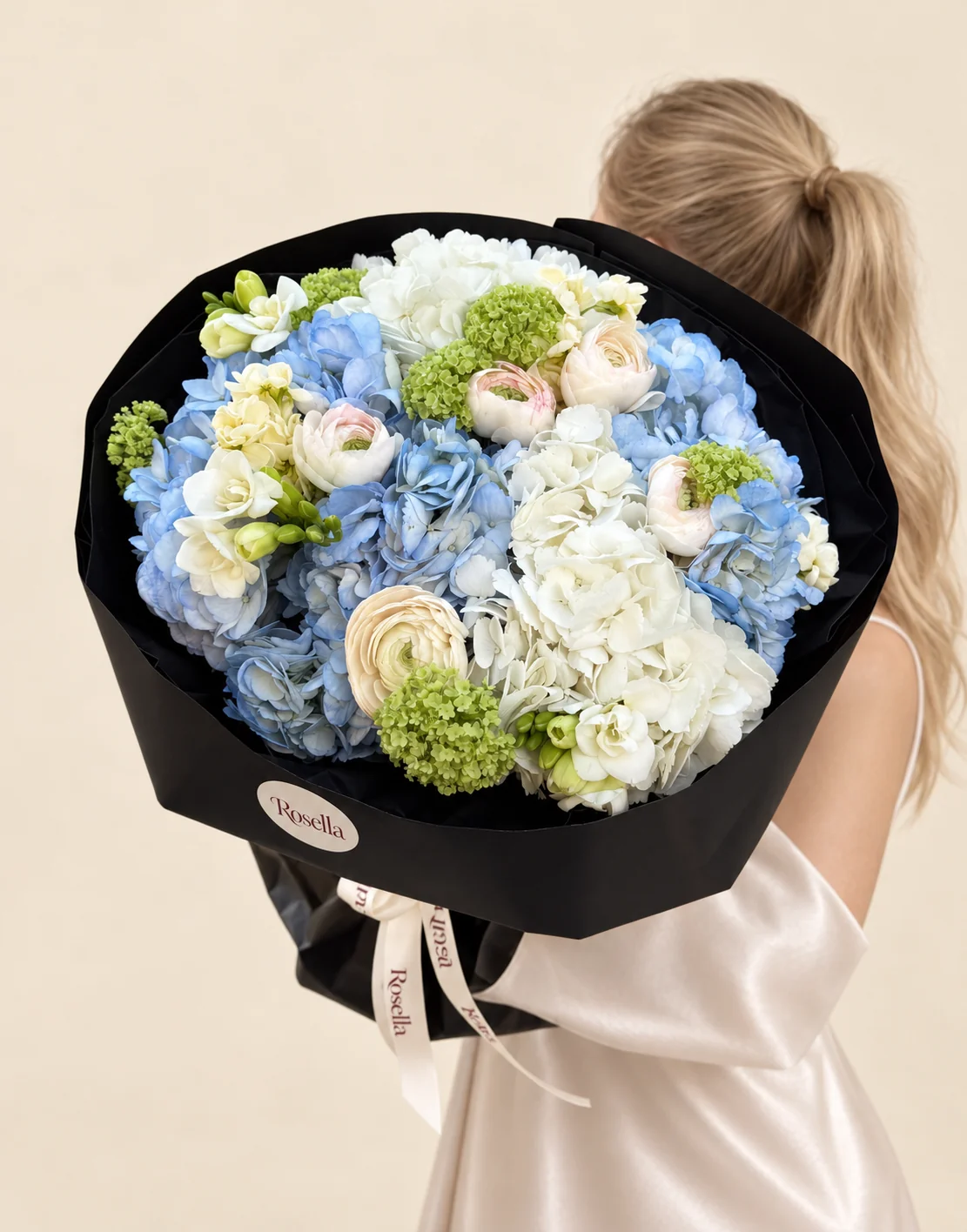 5 blue hydrangeas, 3 white hydrangeas, 5 freesias, 3 ivory ranunculus & 2 white ranunculus in a hand-tied bouquet