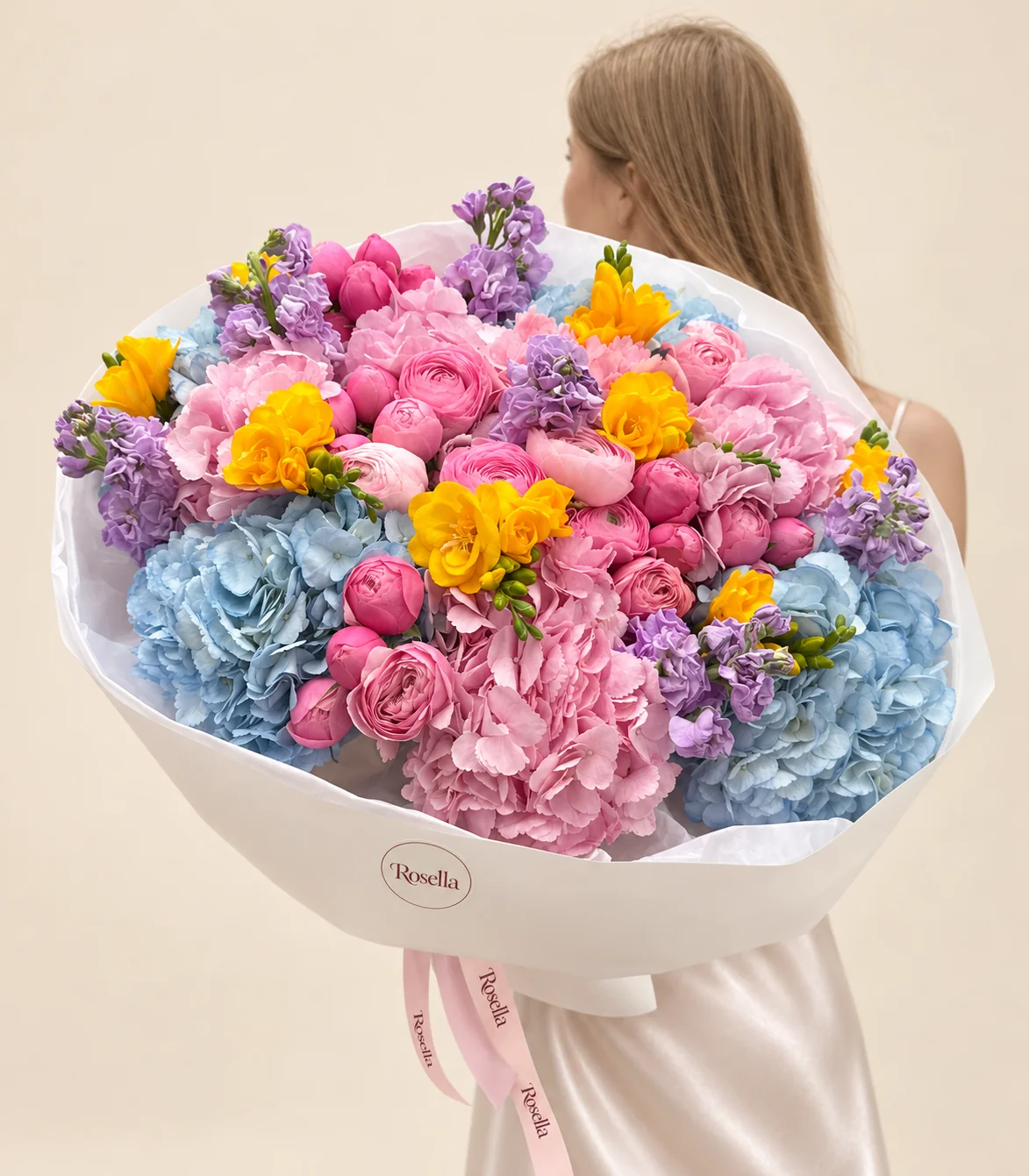 6 pink hydrangeas, 22 pink ranunculus, 4 blue hydrangeas, 4 stocks, 7 freesias & 3 pink ranunculus in a hand-tied bouquet