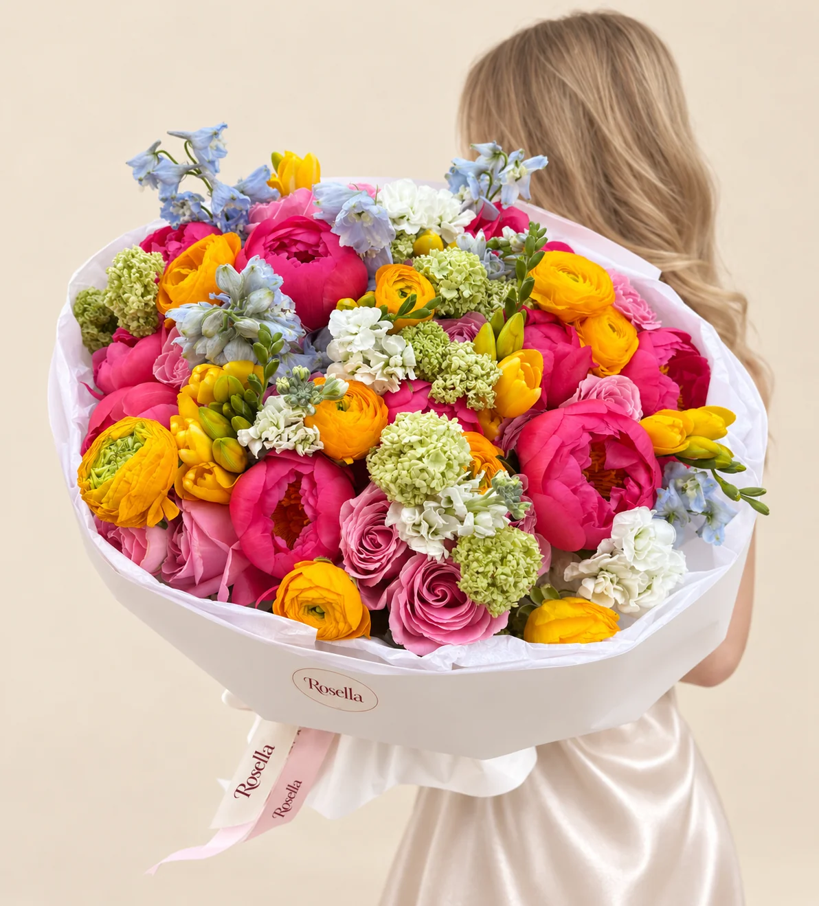 12 peonies, 11 roses, 11 ranunculus, 3 delphiniums, 3 stocks & 4 freesias in a hand-tied bouquet