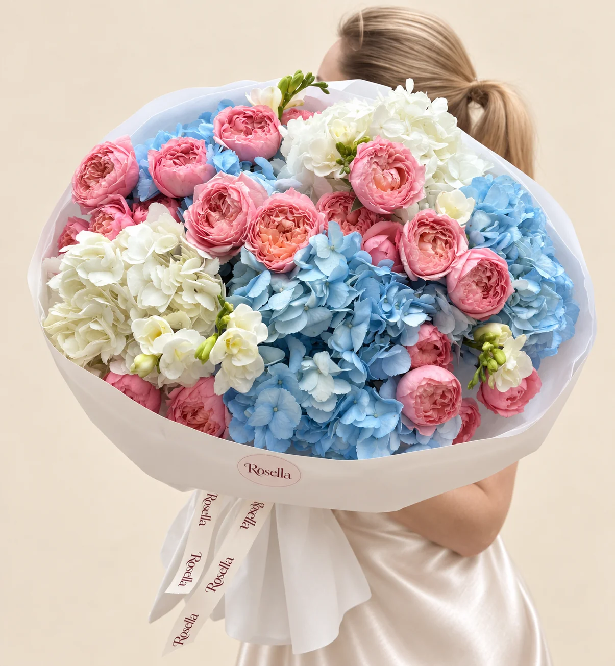 4 blue hydrangeas, 25 spray roses, 2 white hydrangeas & 3 freesias in a hand-tied bouquet