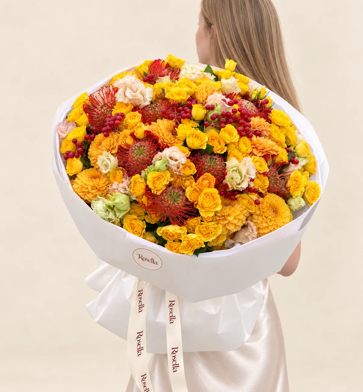 68 roses, 11 red-orange leucospermum (pincushion protea), 10 dahlias, 18 cream lisianthus blooms & 9 green lisianthus blooms in a hand-tied bouquet