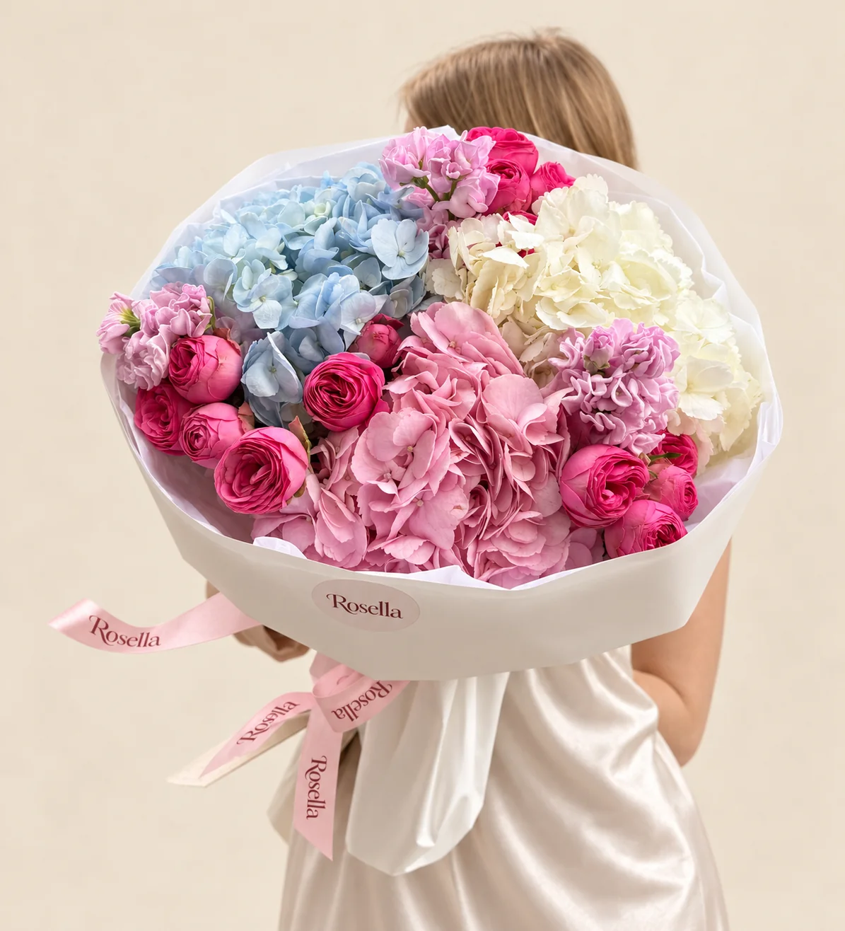 18 spray roses, 3 stocks, 1 blue hydrangea, 1 cream hydrangea & 1 pink hydrangea in a hand-tied bouquet